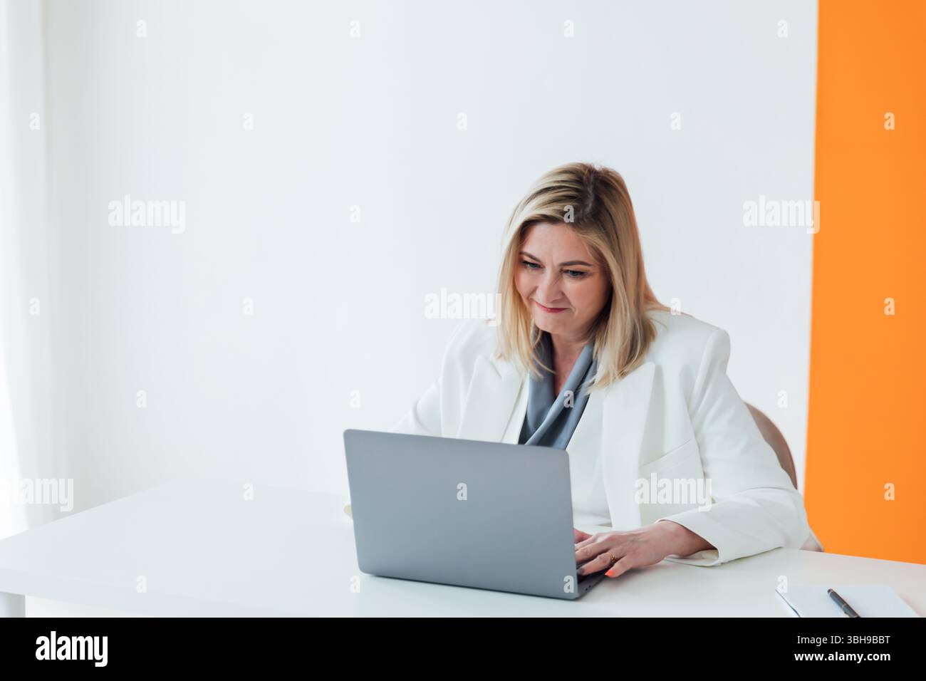 Woman in business suit working with online laptop in office Stock Photo