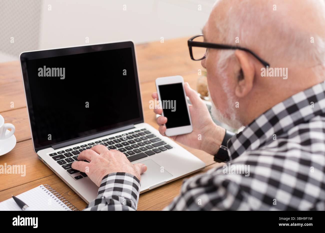 Senior man using laptop and smartphone mockup Stock Photo