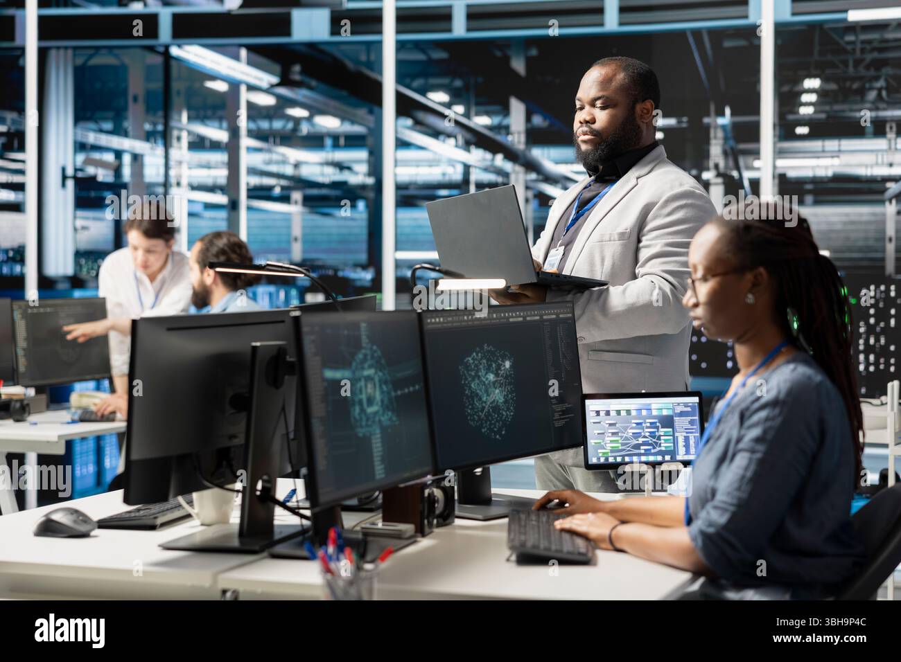 Data center IT experts using artificial intelligence neural networks technology. African american server farm facility software developers using AI programming language on computer to update hardware Stock Photo