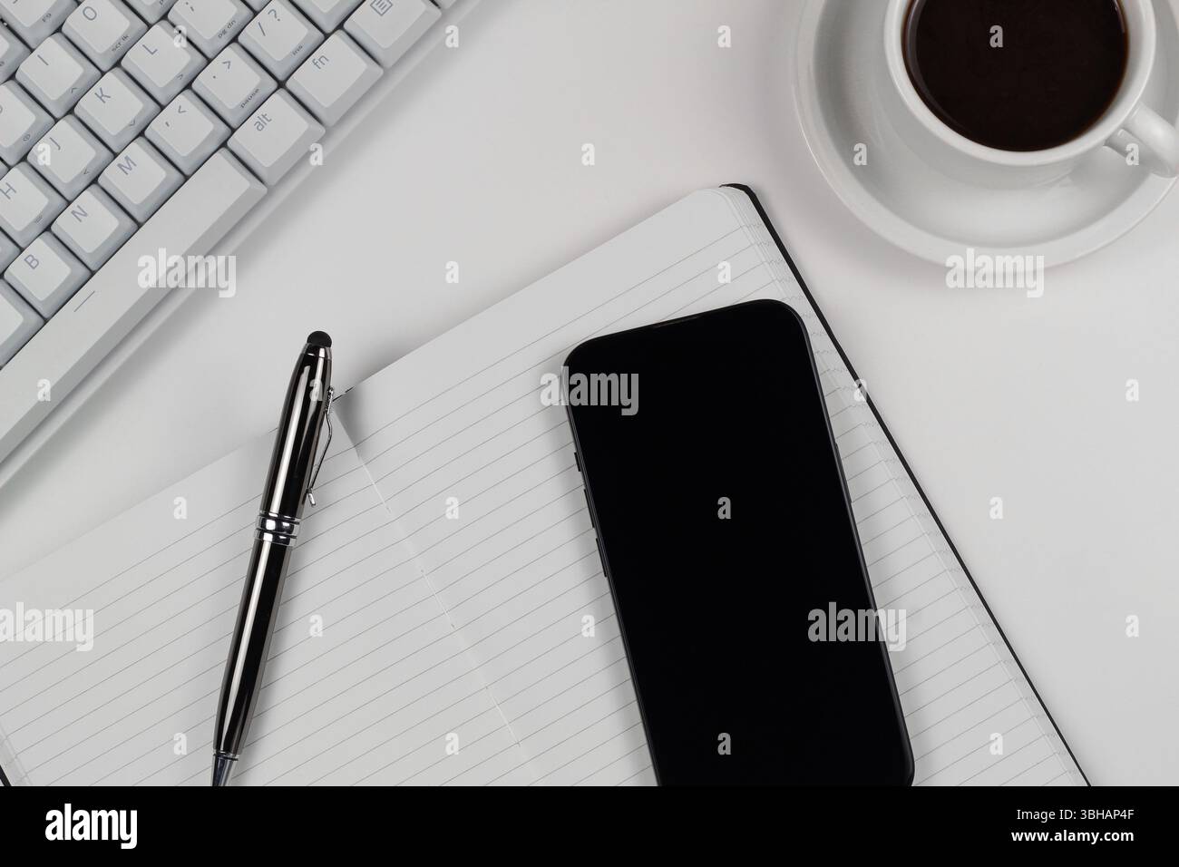 Work Desk Flat Lay with White Keyboard and Smartphone Stock Photo