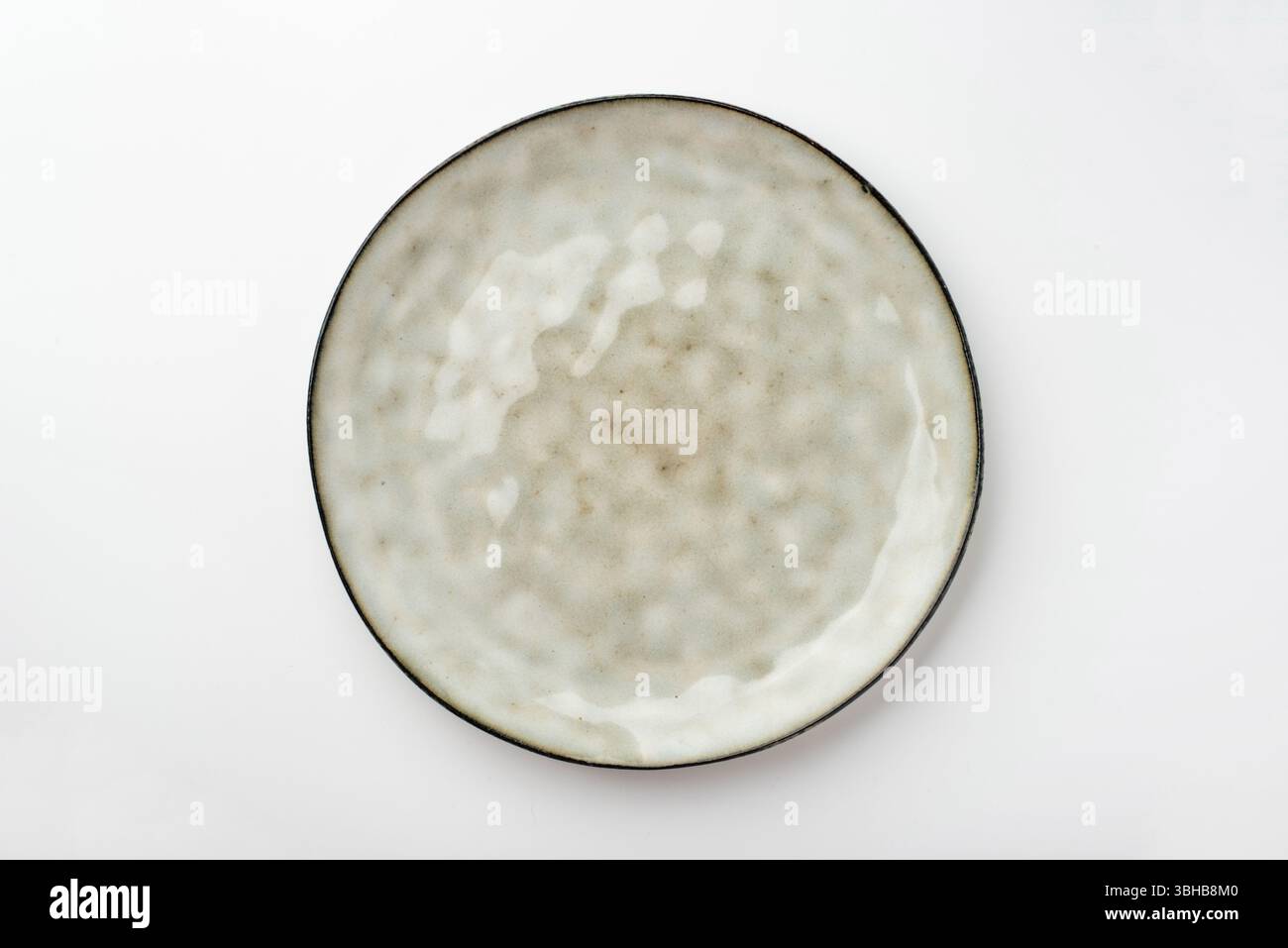 Empty textured plate on white background Stock Photo