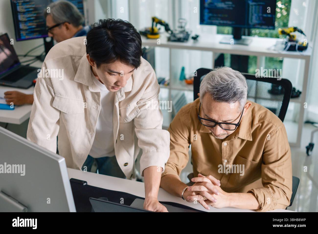 Group of asian senior in a collaborative software development analyzing flowcharts during a bootcamp training Stock Photo