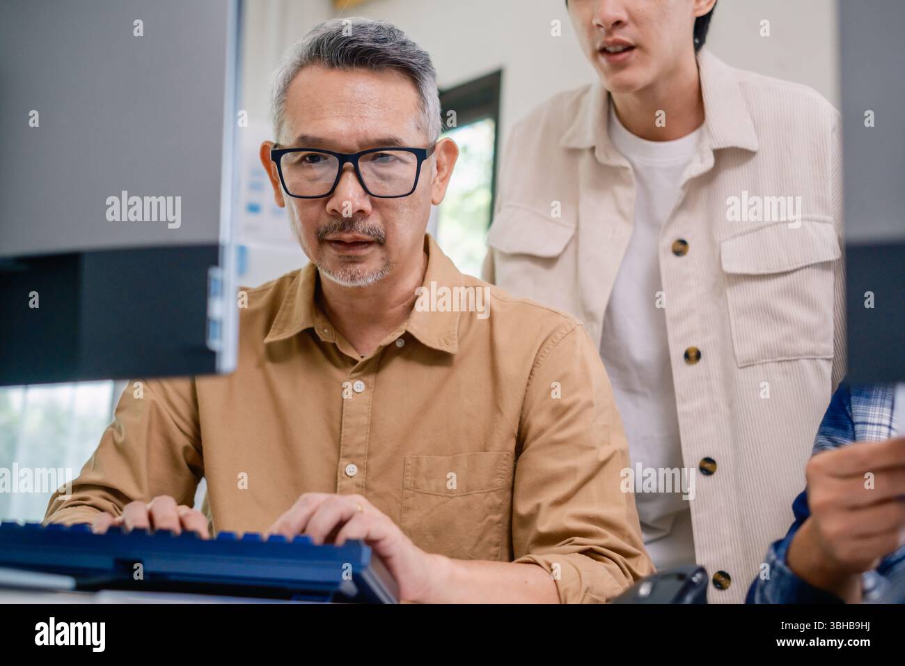 Asian Instructor Teaching Senior in Software Programming and Training Collaboration Stock Photo