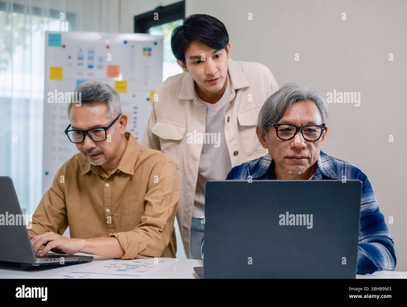 Asian Instructor Teaching Senior in Software Programming and Training Collaboration Stock Photo