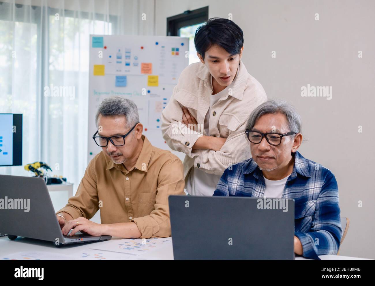 Asian Instructor Teaching Senior in Software Programming and Training Collaboration Stock Photo