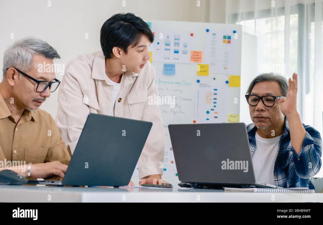 Asian senior bootcamp team asking and  learning programming with software training and whiteboard collaboration Stock Photo