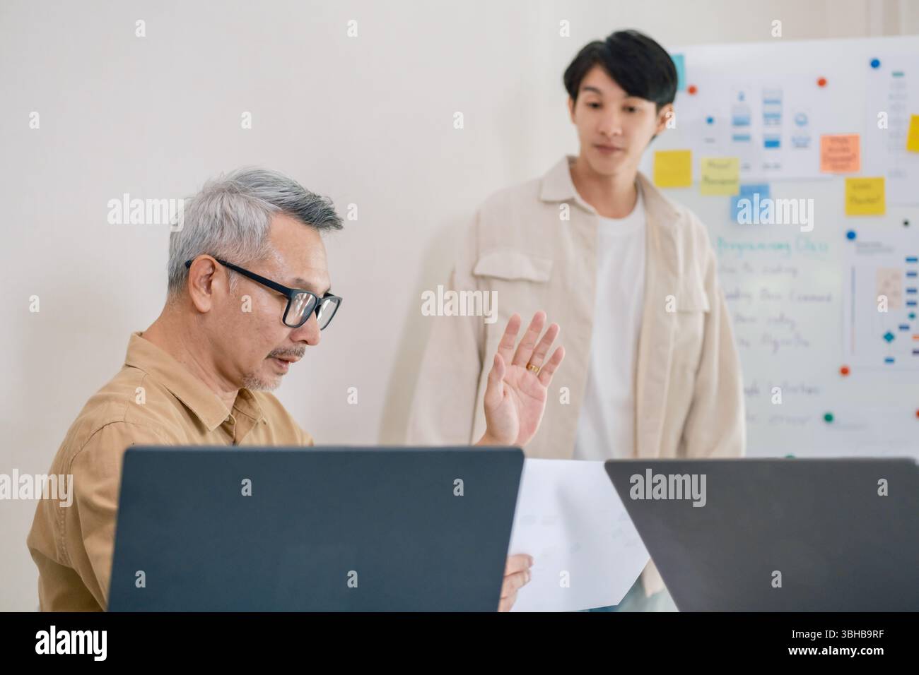 Asian senior bootcamp team asking and  learning programming with software training and whiteboard collaboration Stock Photo