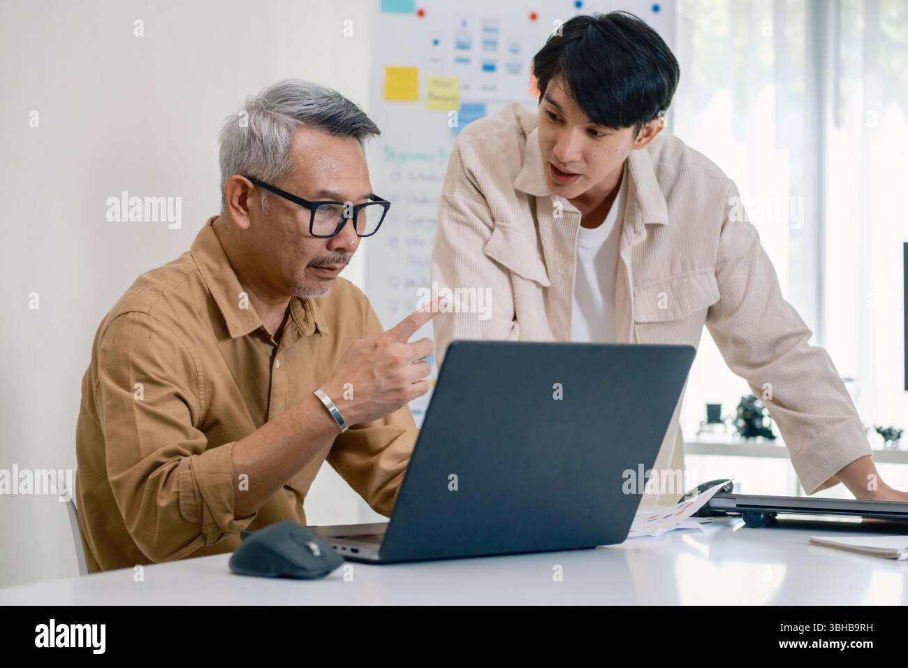 Asian senior bootcamp team asking and  learning programming with software training and whiteboard collaboration Stock Photo