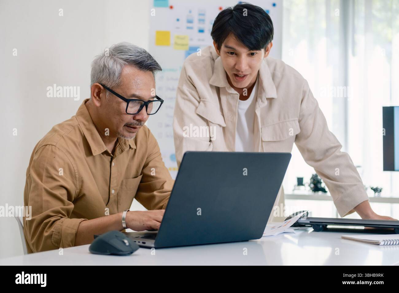 Asian Instructor Teaching Senior in Software Programming and Training Collaboration Stock Photo