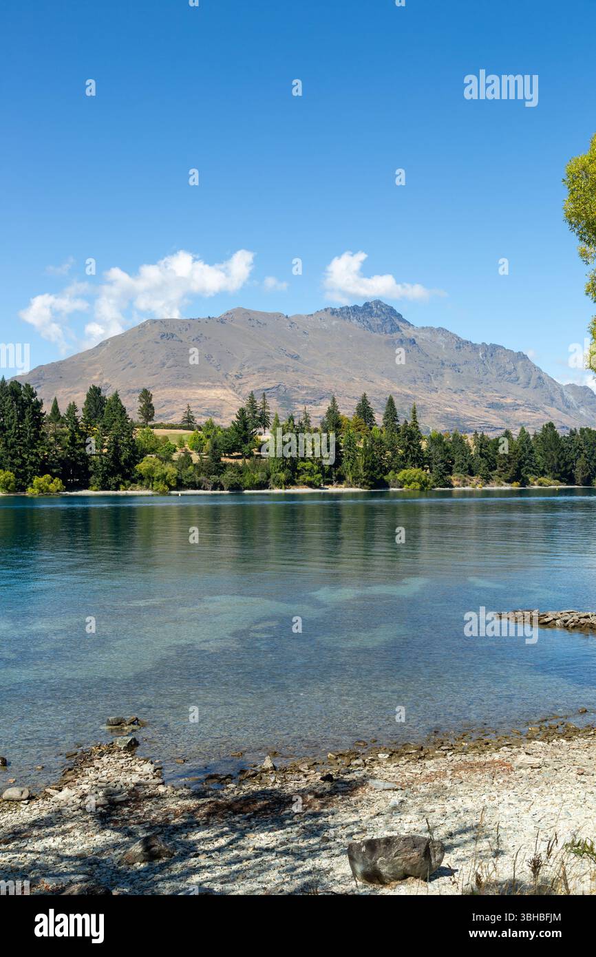 Sunshine Bay Beach on the shores of Lake Wakatipu with mountains in the distance, Queenstown, Otago, New Zealand Stock Photo