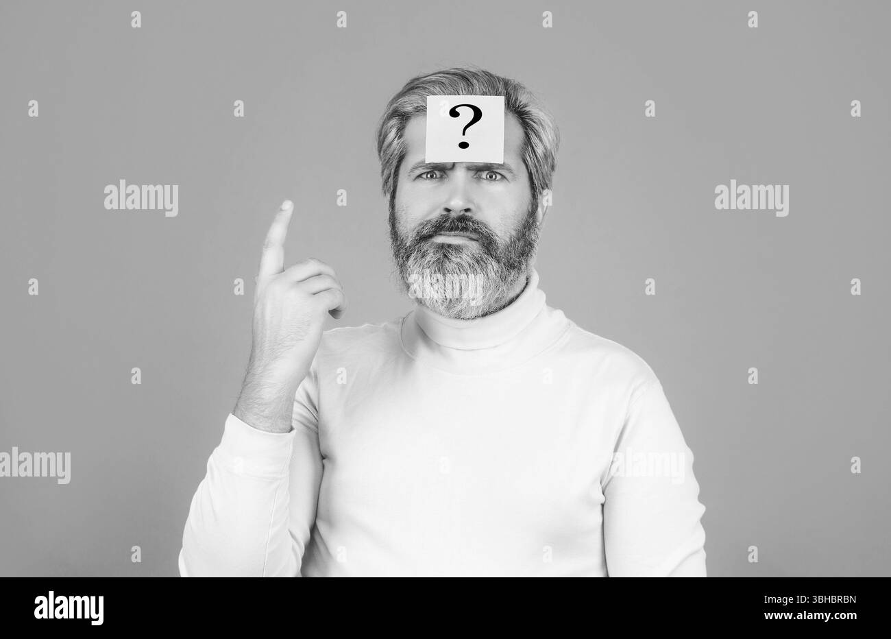 Thoughtful young man and sticky note with question mark on his forehead against. Beard man question mark in head, solution problems. Paper notes with Stock Photo