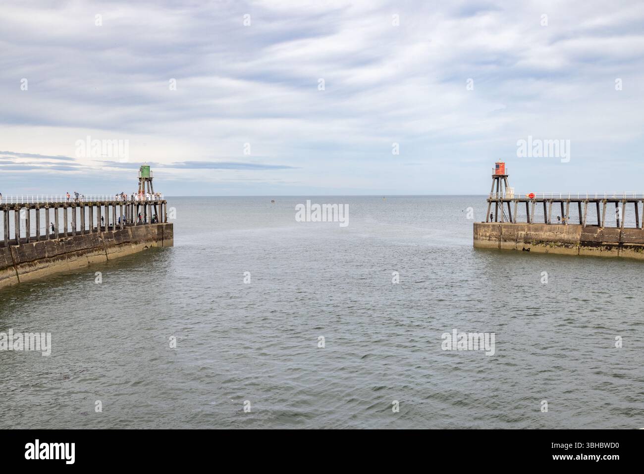 Whitby’s East and West piers lead out to the North Sea, a striking feature of this historic harbour and popular UK seaside destination. Whitby tourism Stock Photo