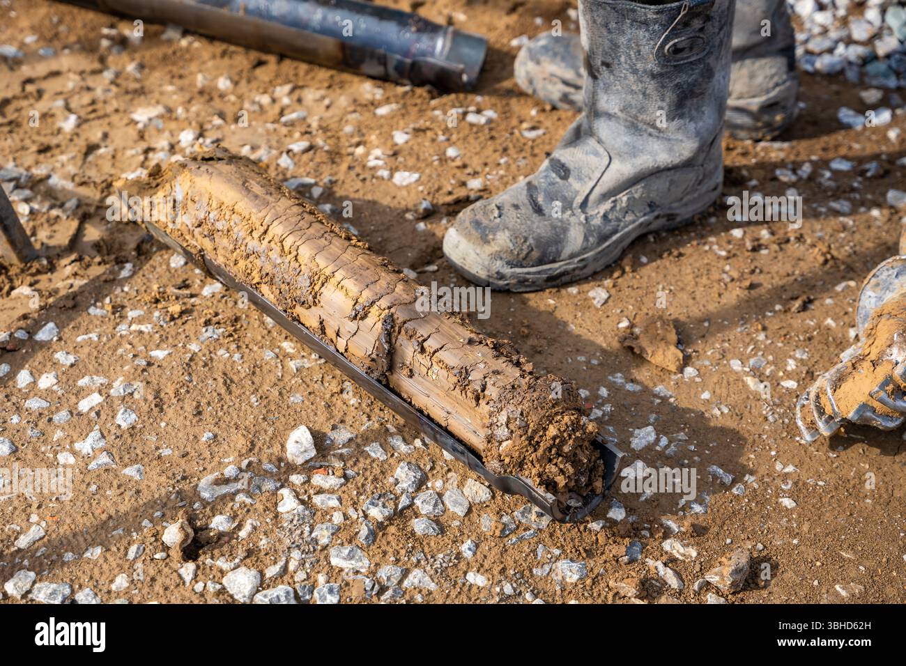 Fresh soil core sample placed on the ground after drilling. Subsurface ...