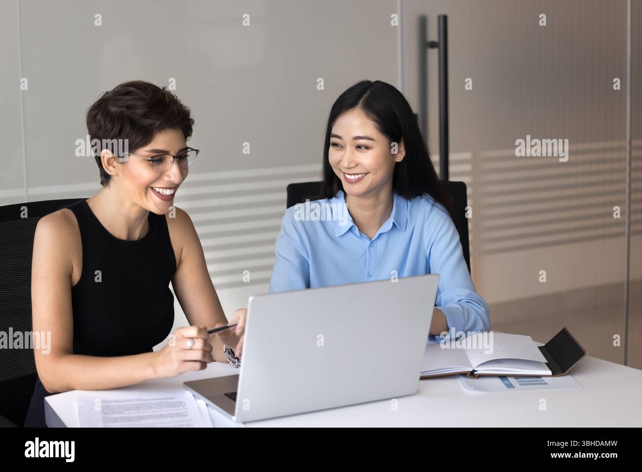 Two Team Members Two team members communicate project hi-res stock photography and ...