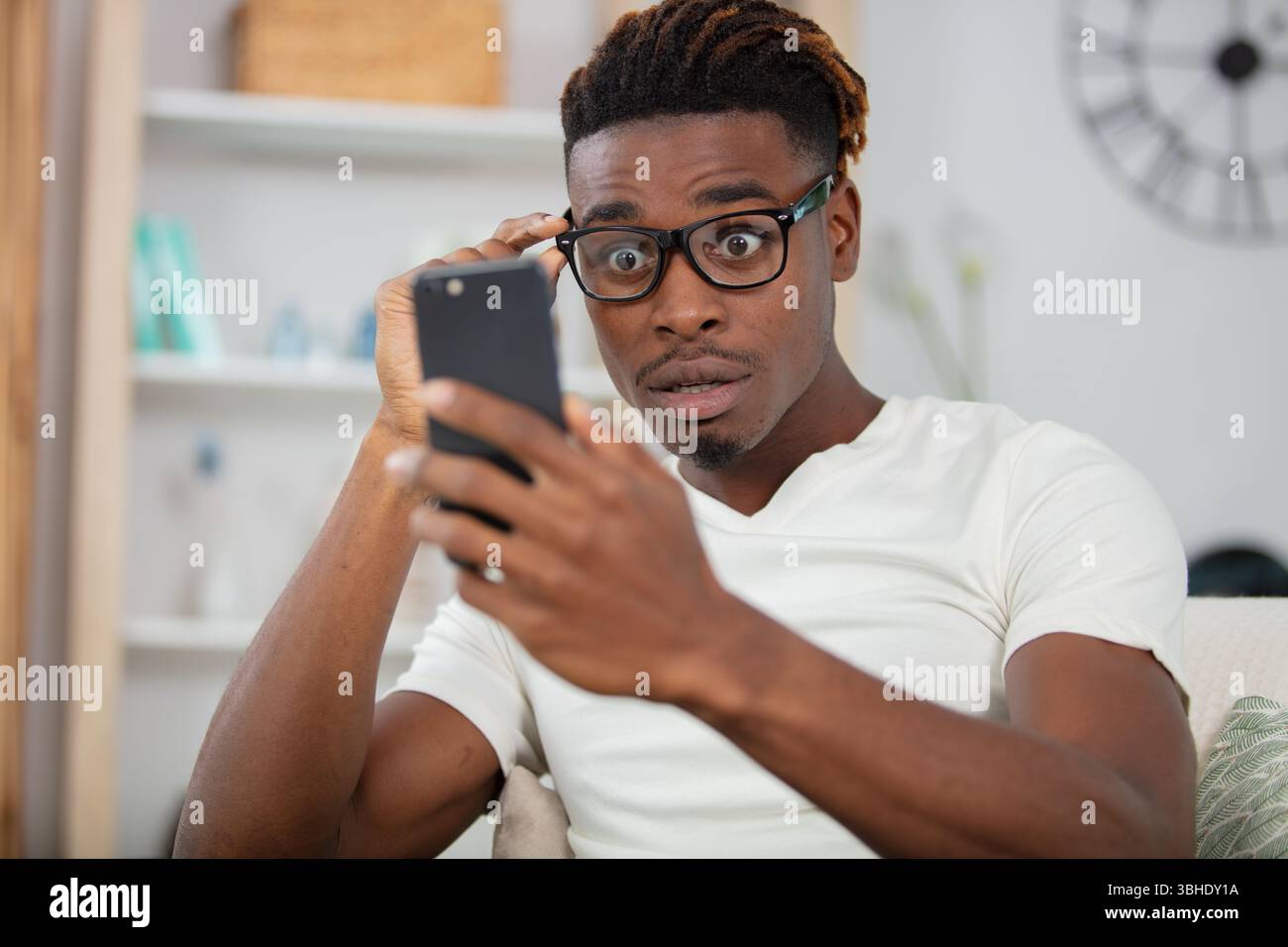 surprised happy african man holding phone Stock Photo