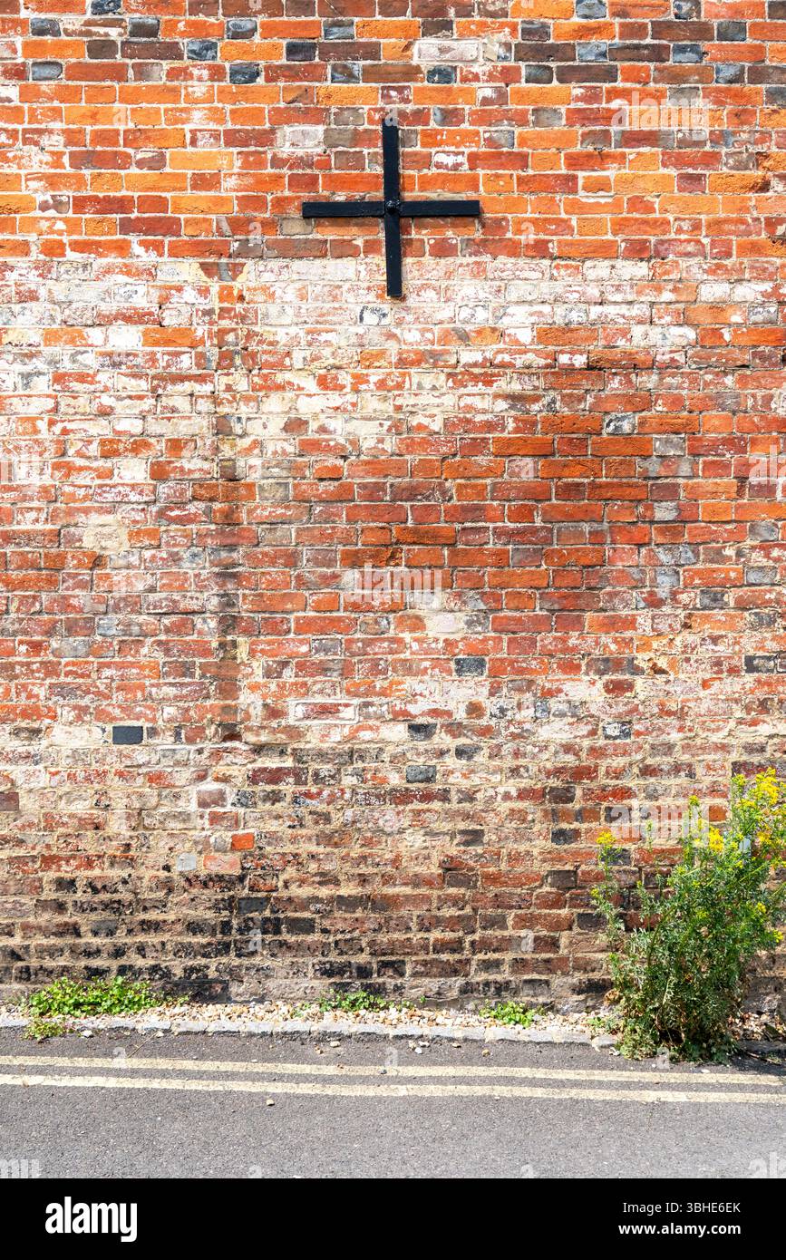 Old red brick wall with black metal wall tie Stock Photo