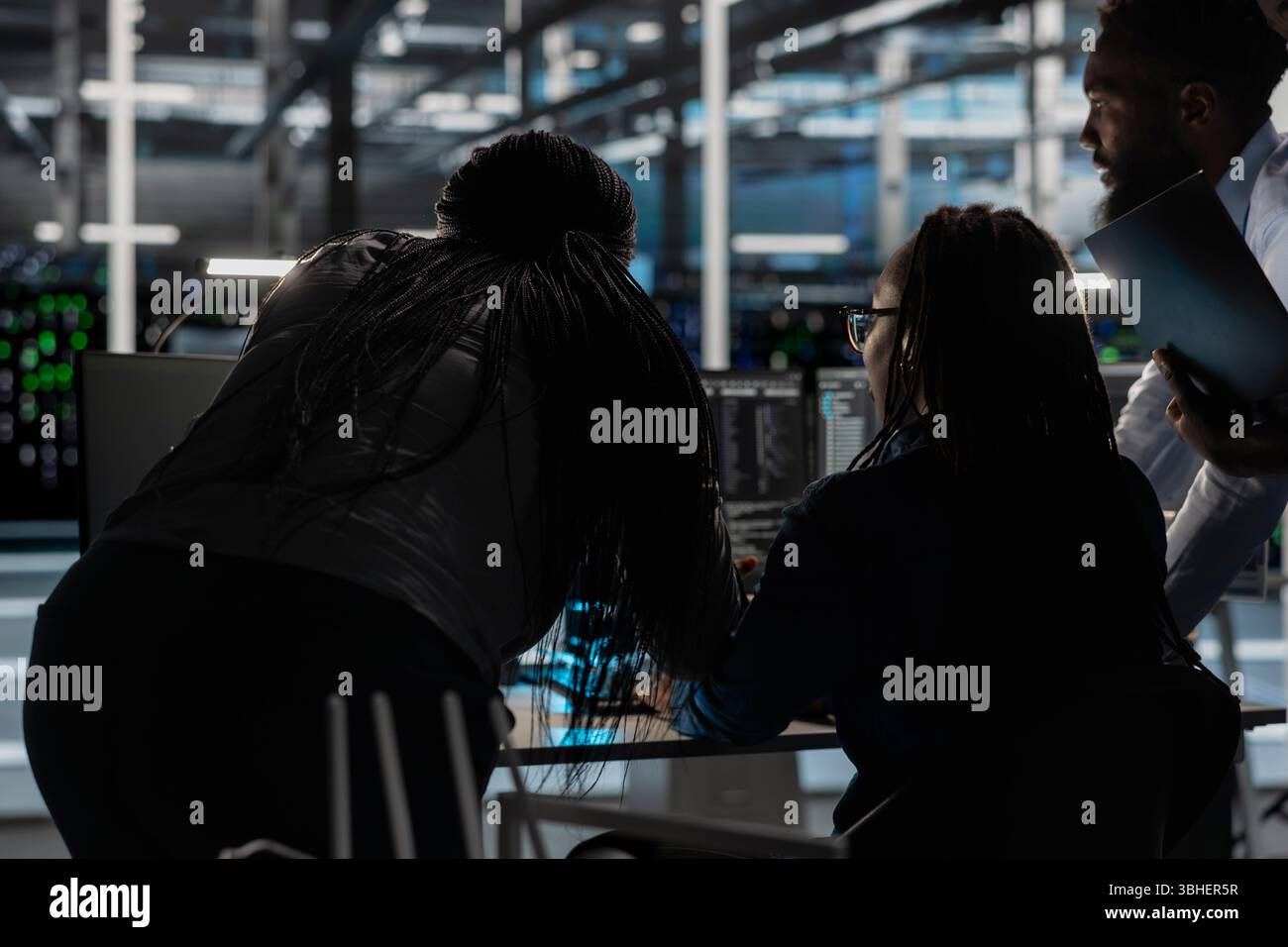 Server farm engineering team implementing and managing data backup solutions. Teamworking data center colleagues identifying and resolving technical errors, ensuring efficient recovery Stock Photo