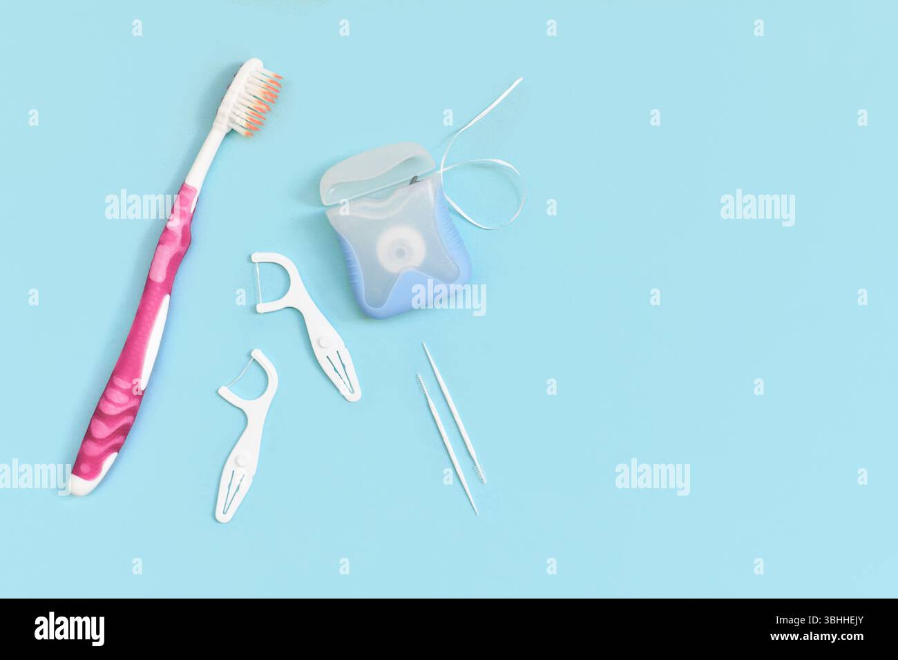 Dental floss, toothpicks and brush on side of blue background with copy ...