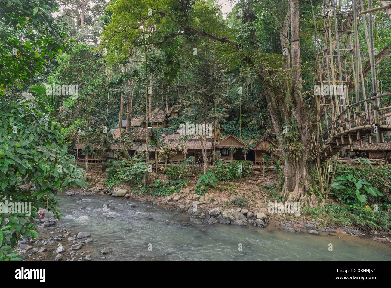 Jungle landscape view of huts and bamboo bridge over river in Gazebo village of Badui or Baduy Luar ethnic group, Lebak, Banten, West Java, Indonesia Stock Photo