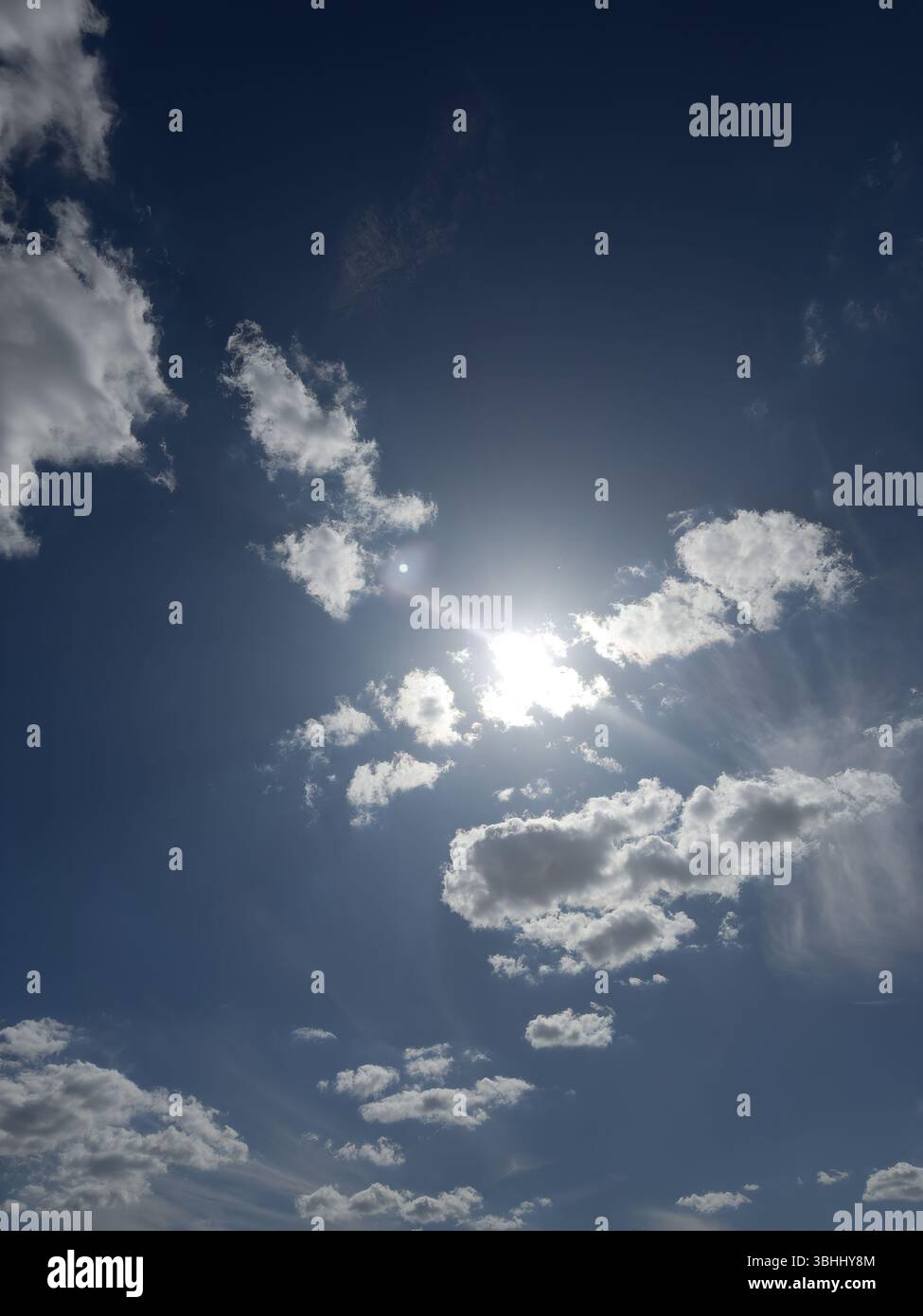 Bright sun behind white light clouds. nature background - Smartphone Captured Stock Image