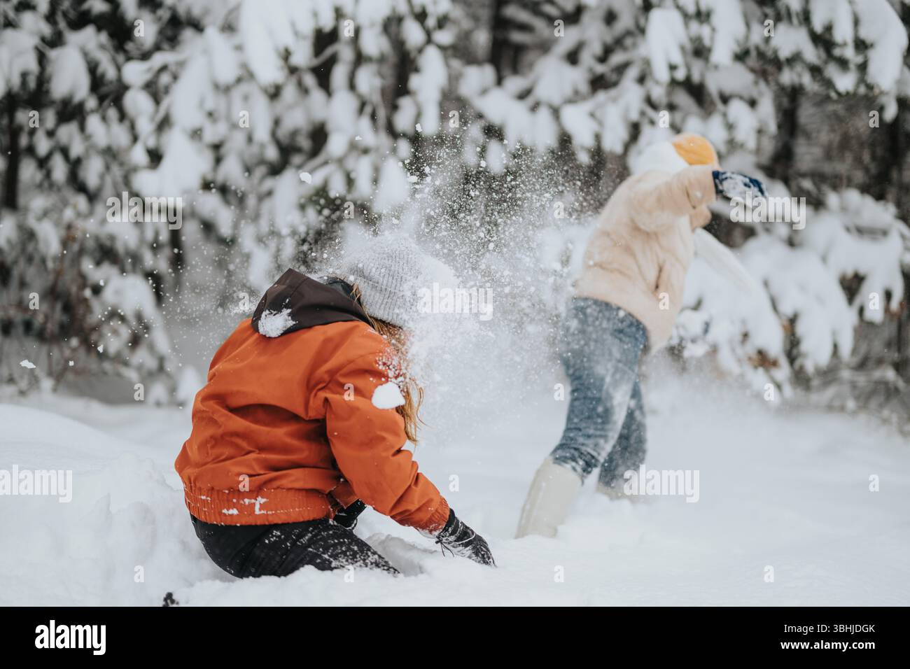 Two children playing joyfully in the snow surrounded by a beautiful ...