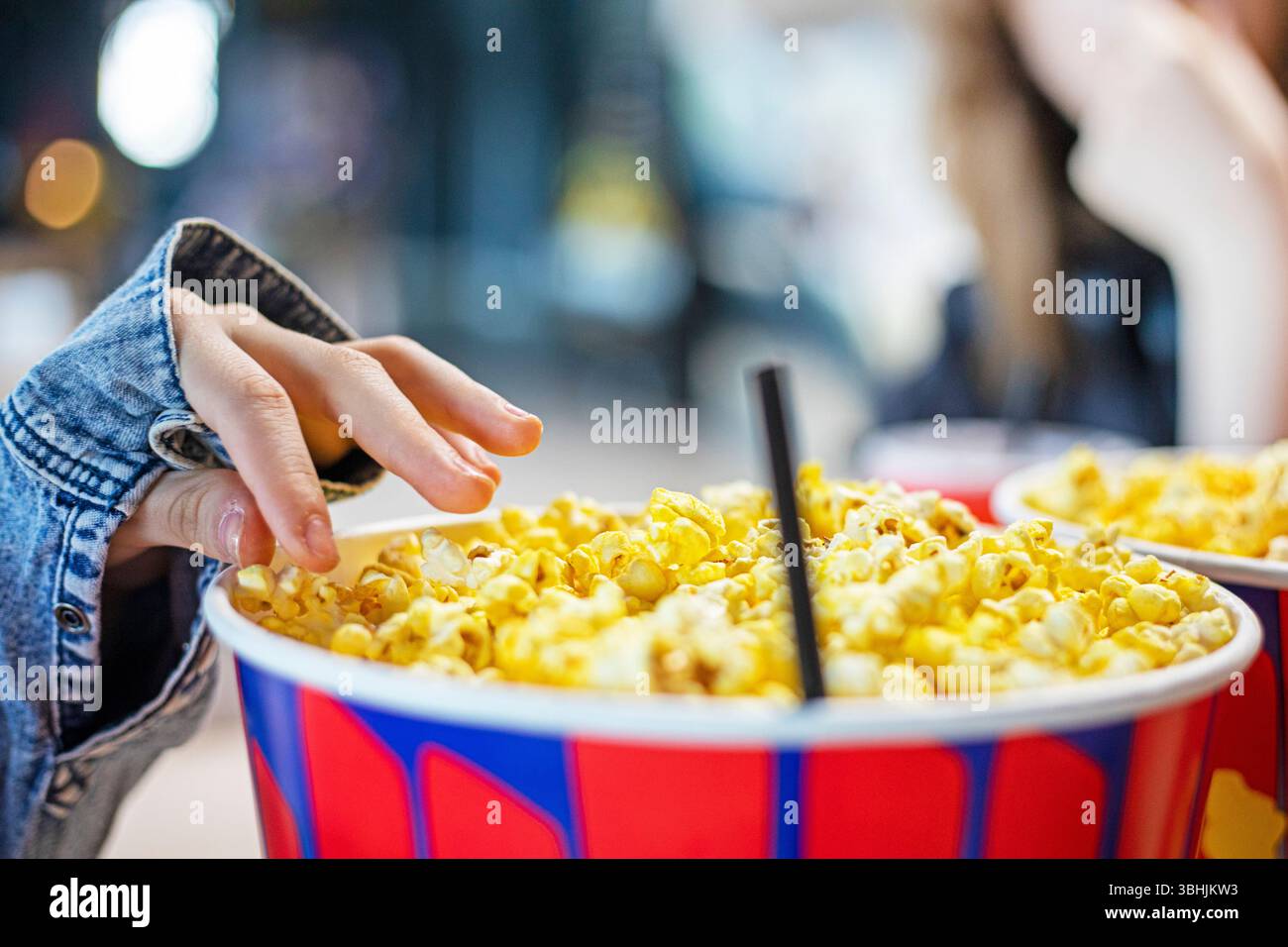 Weekend Popcorn eating salty, cheese and caramel popcorn with family at the cinema ...