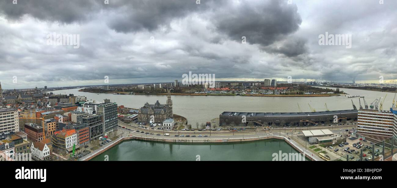 An expansive panoramic view of a cityscape alongside a river. Featuring ...