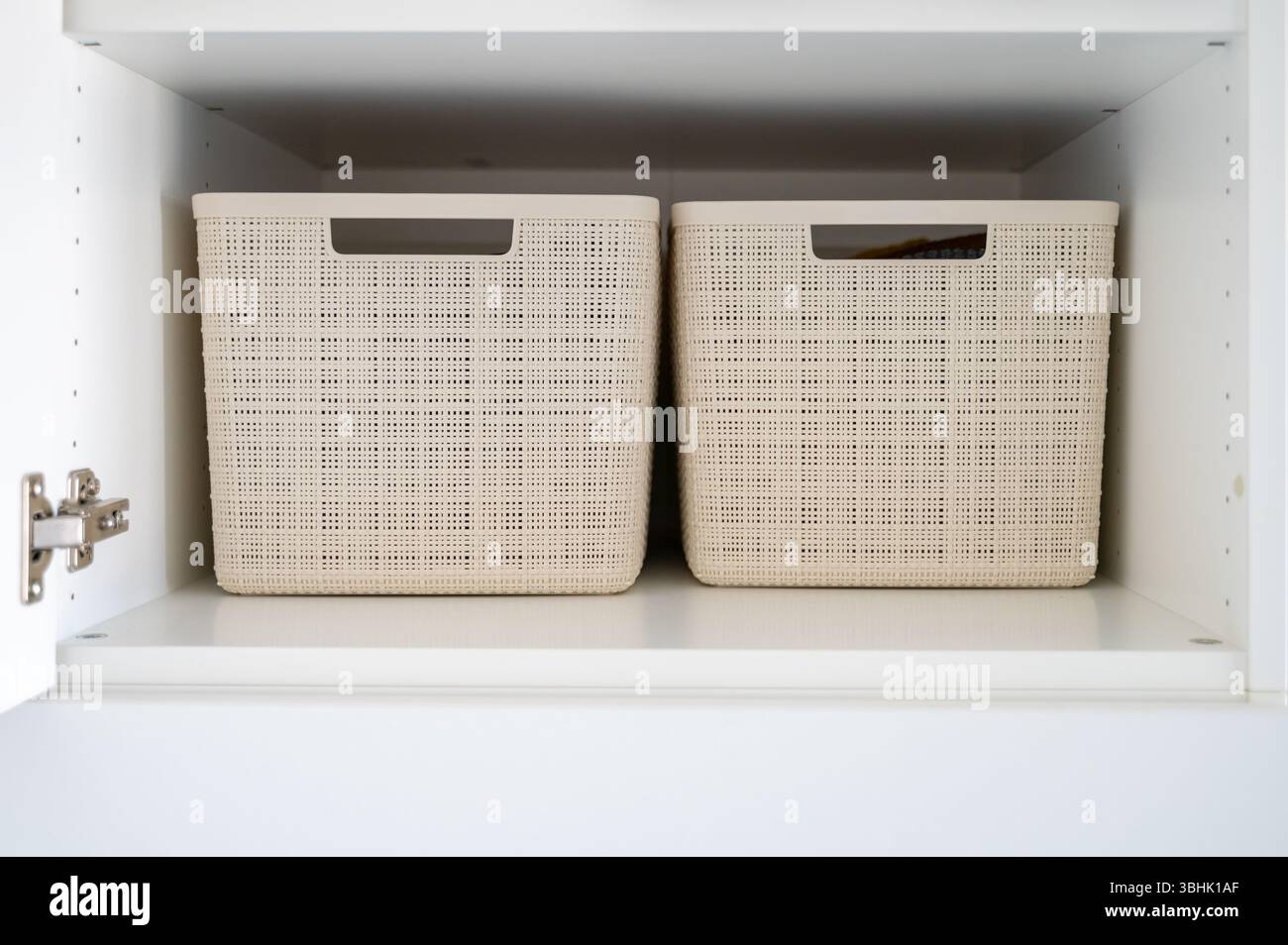 View inside wardrobe at one shelf, on it stand two plastic storage ...