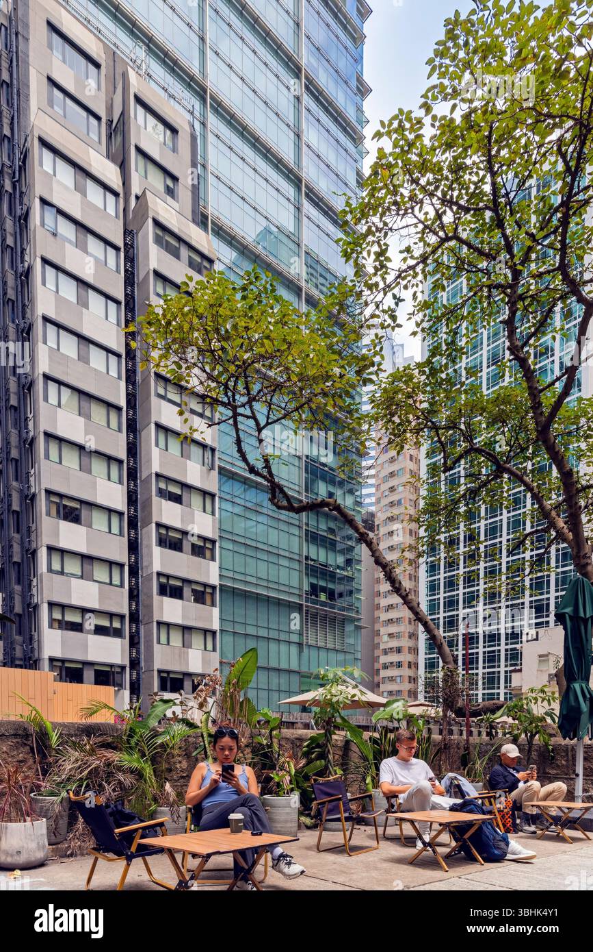 People sitting and relaxing amid high rise buildings landscape, in mid ...