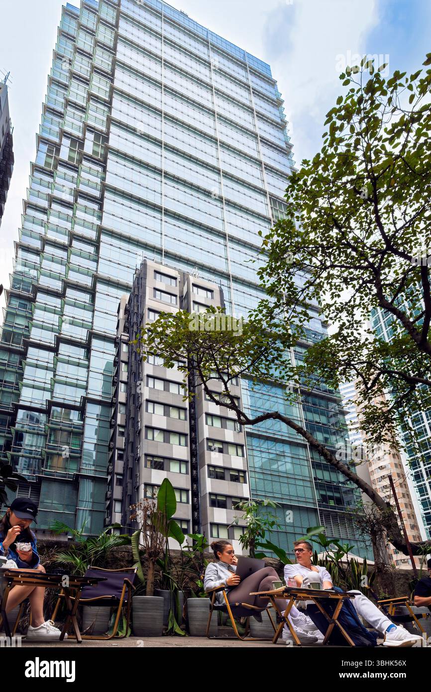 People sitting and relaxing amid high rise buildings landscape, in mid ...