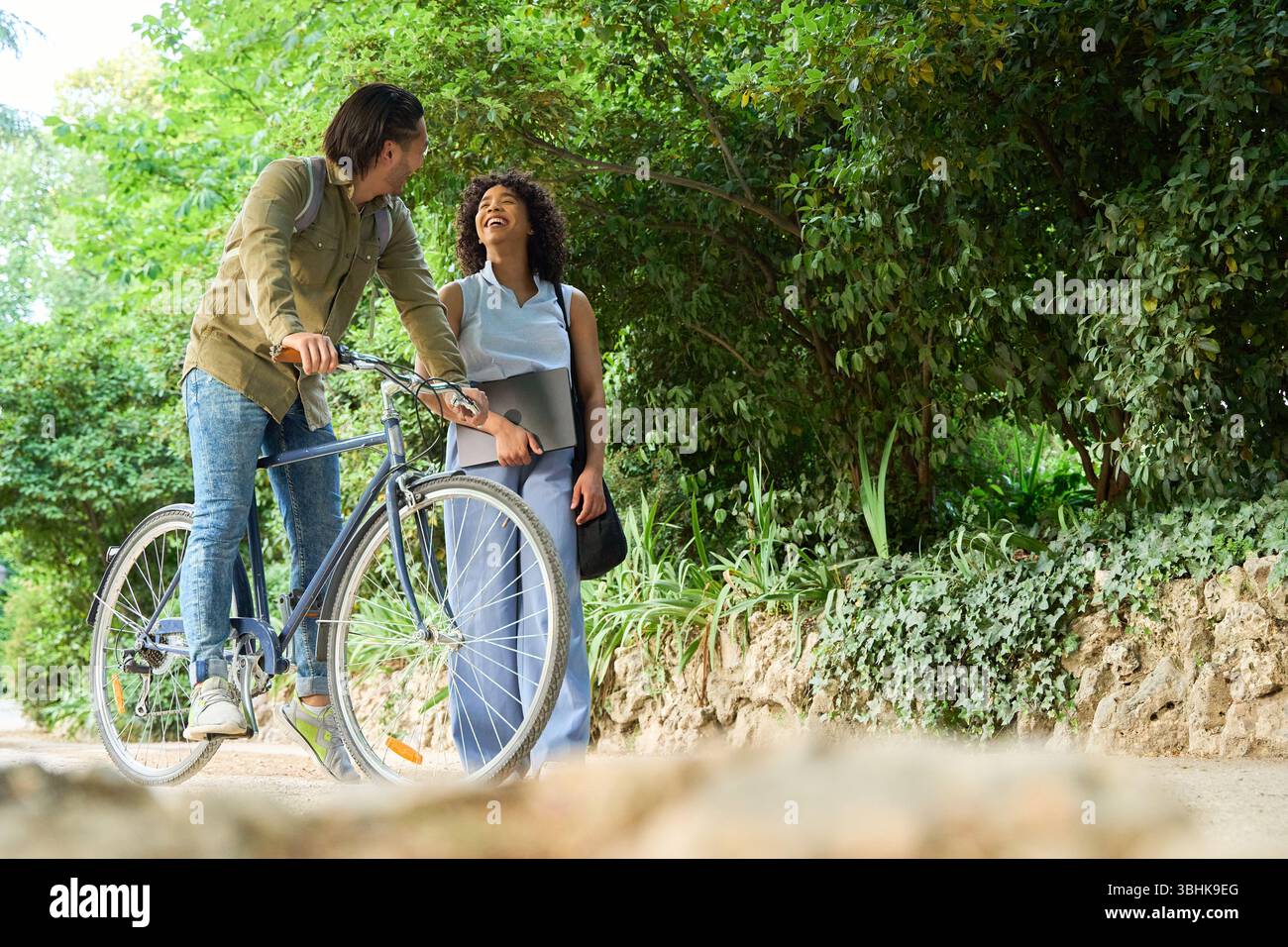 Business colleagues enjoying a relaxing break, walking and cycling ...