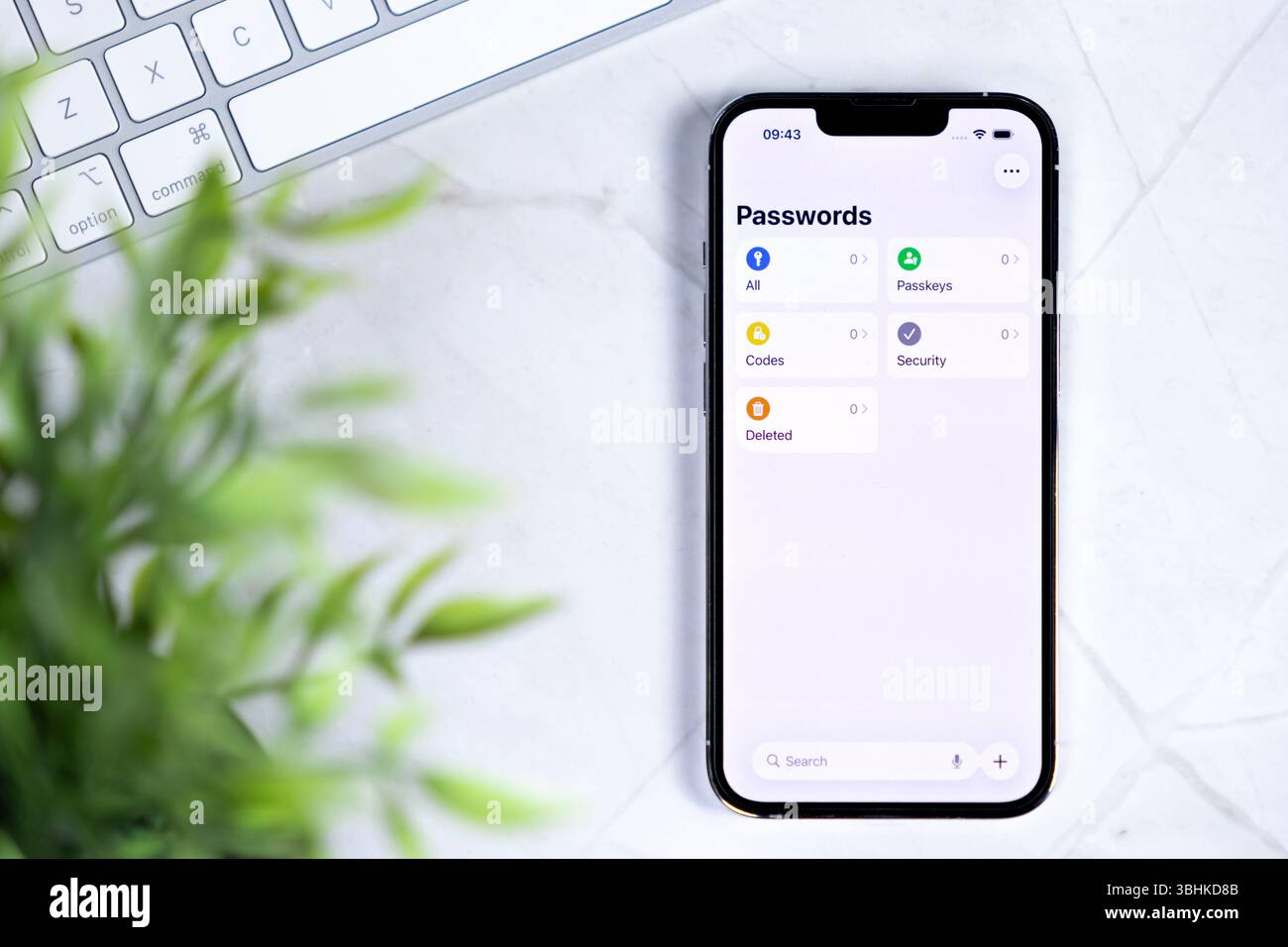 Poznan, Poland - June 10, 2025: New iOS 26 Liquid Glass smartphone on a white desk, displaying a modern password manager for enhanced digital security Stock Photo
