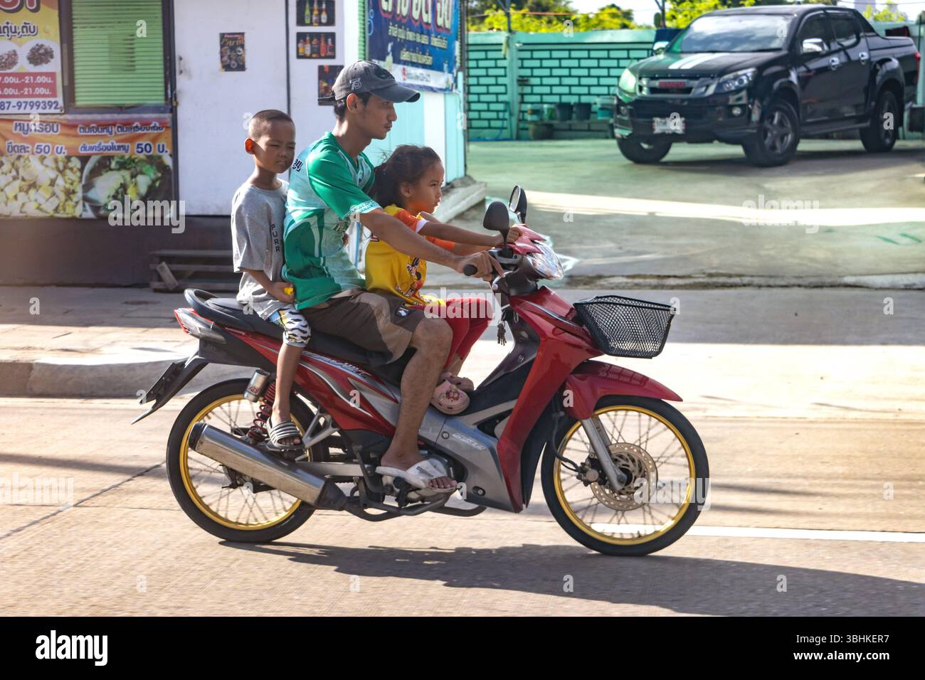 SAMUT PRAKAN, THAILAND, JUNE 01 2025, Man with children riding a motorbike in the city Stock Photo