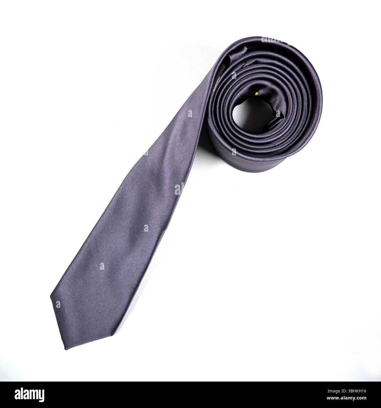 A black tie rolled on white background close-up view Stock Photo