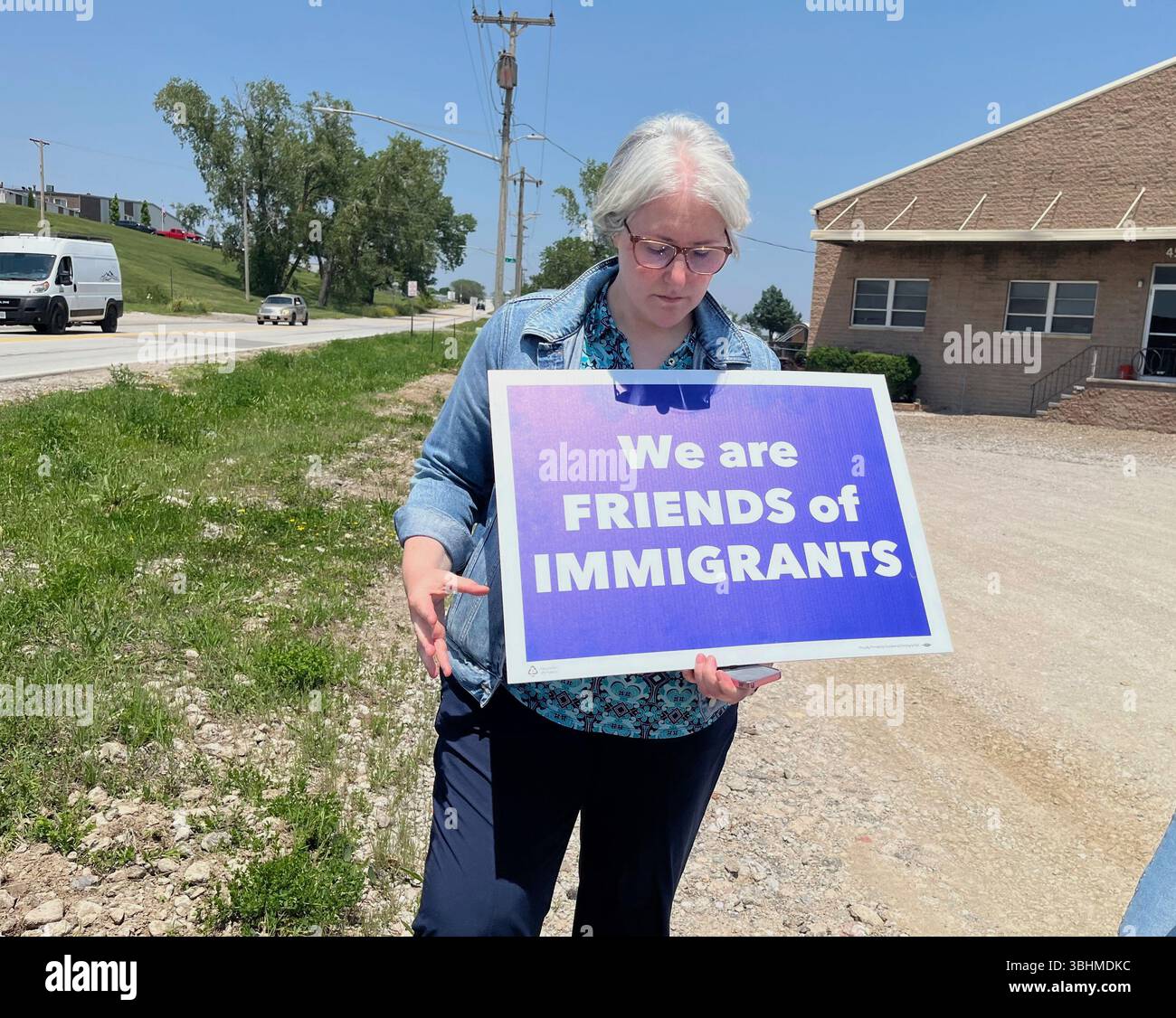 Sara Schulte-Bukowinski, a faith leader in Omaha, Neb., holds a sign ...