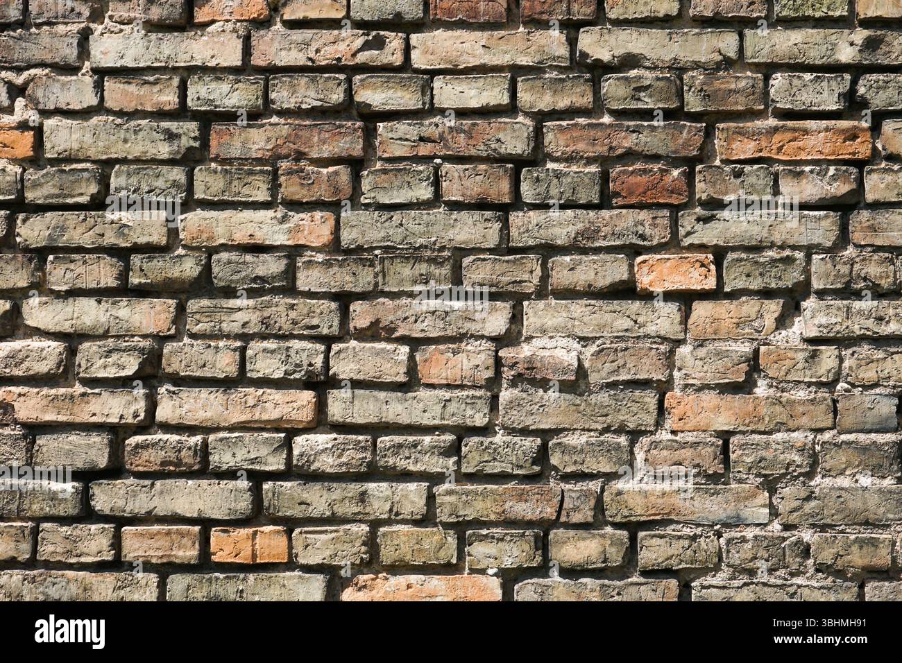 Old brick wall background. Vintage red and gray stone texture. Grungy weathered surface. Exterior structure facade. Historic rustic design. Stock Photo