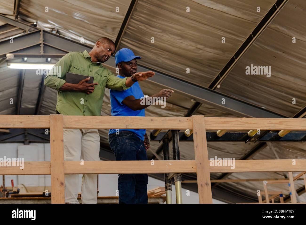 African American coworkers inspecting tablet standing on platform amid ...
