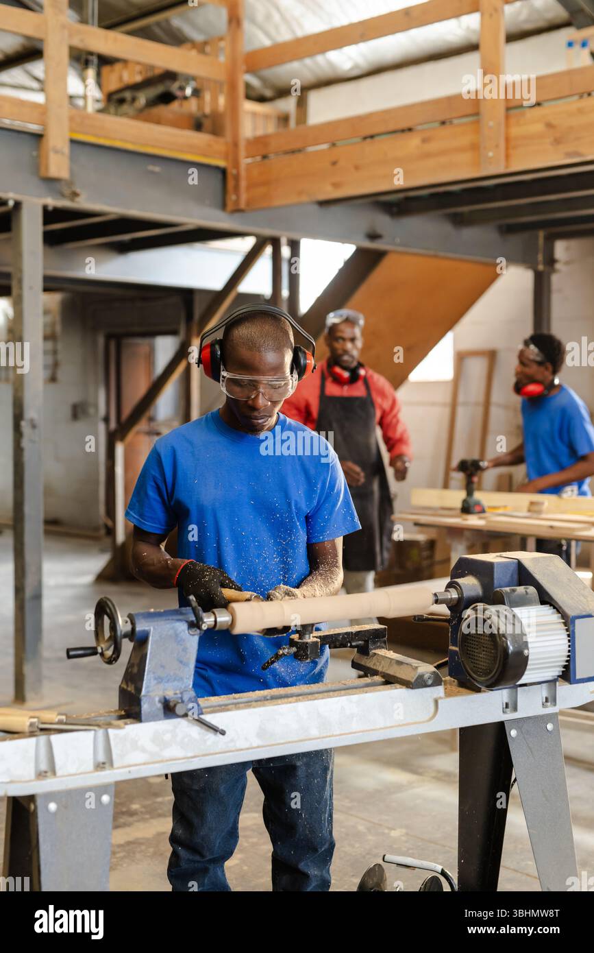 African American male coworkers working at shop shaping spindle at ...