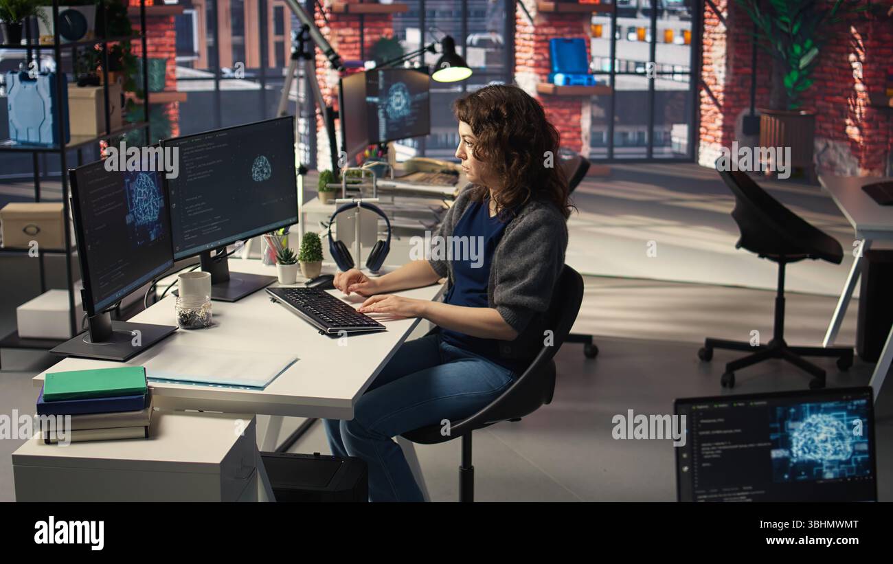 Woman IT developer using pc setup for artificial intelligence cloud computing through self learning algorithms. Agency system engineer works with AI deep neural networks on desktop. Camera A. Stock Photo