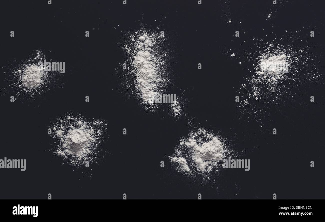 Sprinkled wheat flour splash spots on black background Stock Photo