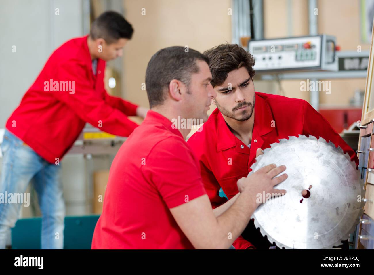student and teacher in carpentry class using circular saw Stock Photo
