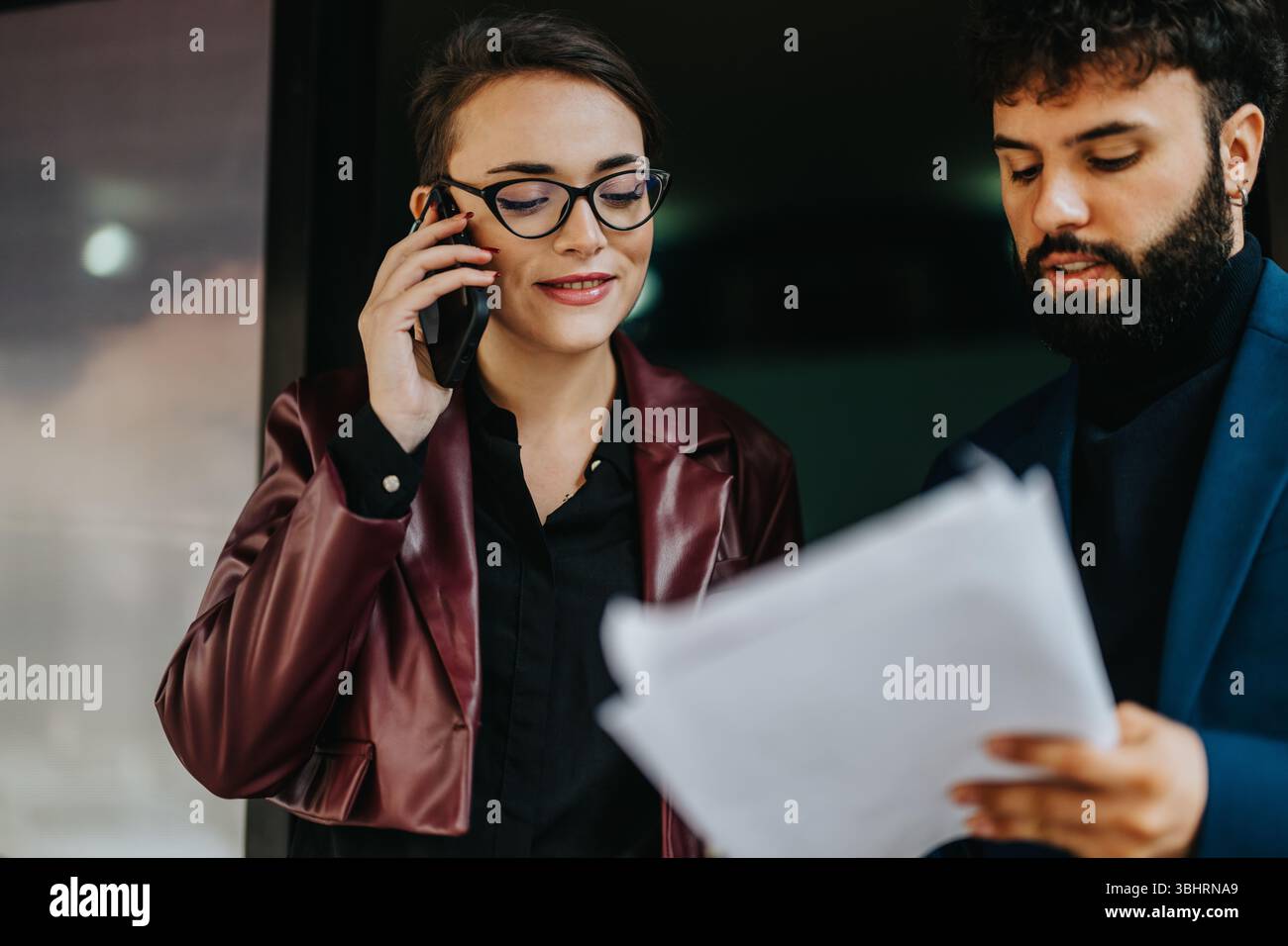 Professional Collaboration Between Two Colleagues Communicating and Reviewing Documents Stock Photo