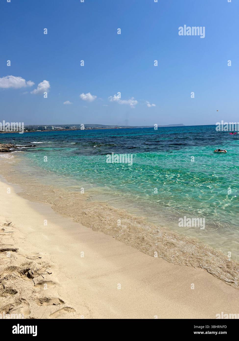 Golden sand meets crystal-clear turquoise waters under a bright blue sky. A peaceful beach scene perfect for summer, travel, or vacation themes. - Smartphone Captured Stock Image