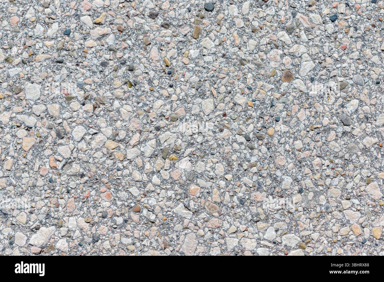 A full-frame close-up shows a light gray concrete surface embedded with ...