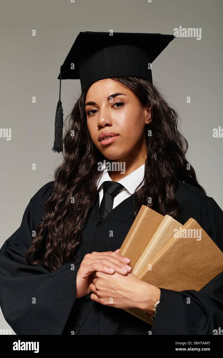 Brightly lit backdrop surrounds a young woman proudly holding her books ...