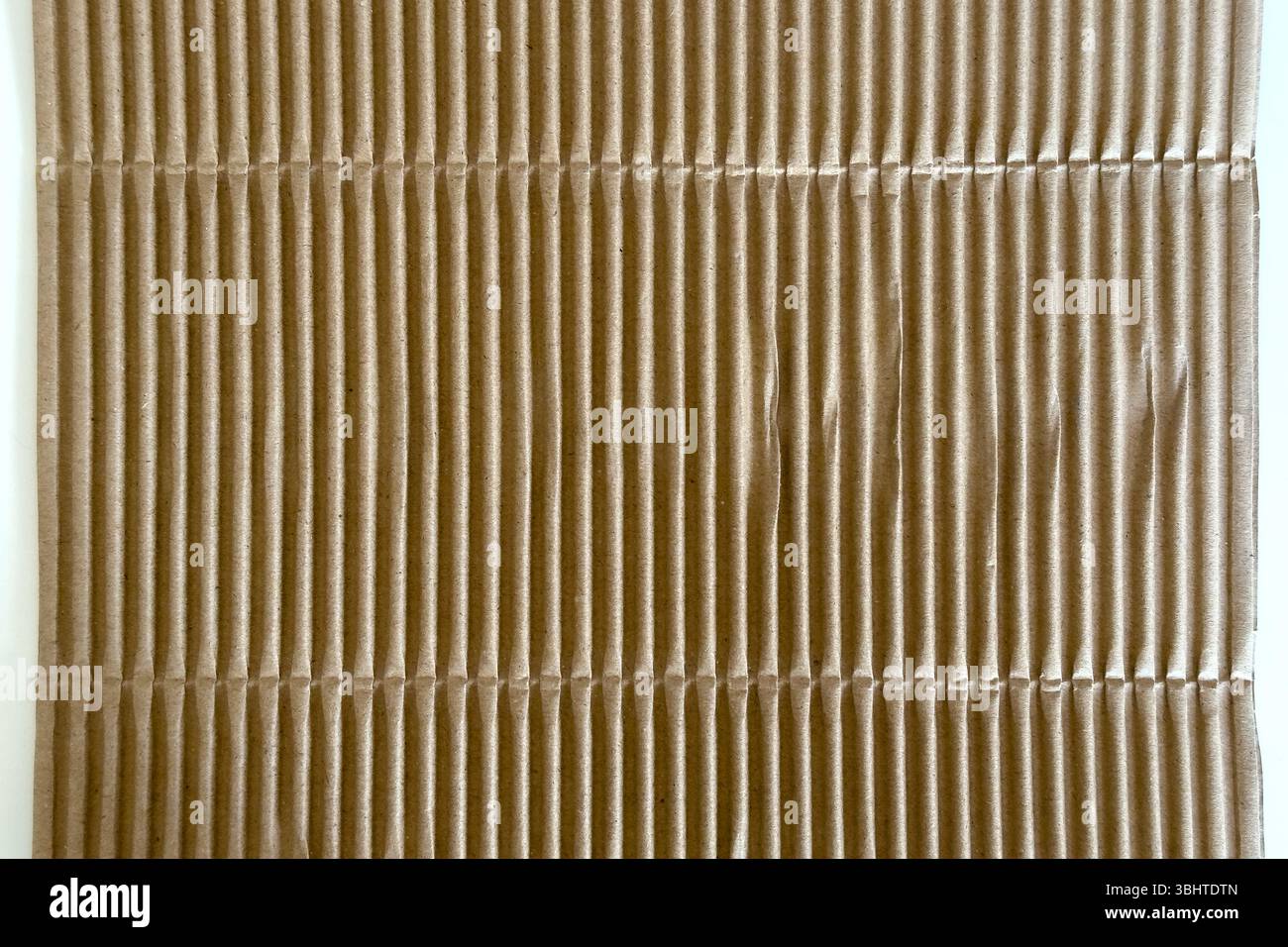 Corrugated brown packaging cardboard paper on white table. Abstract background Stock Photo