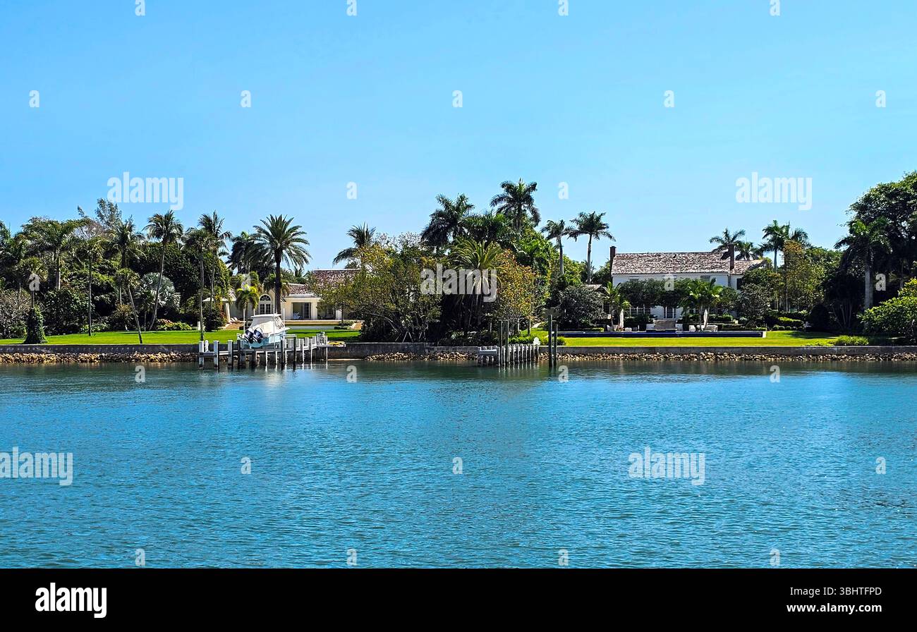 Beautiful waterfront homes on Jupiter Island, Florida. Manicured landscaping and private docks are typical of the gracious homes on the Hobe Sound sid - Smartphone Captured Stock Image