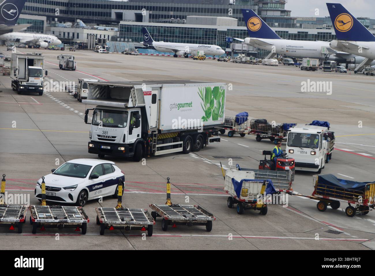 Ground vehicles, Gate Gourmet truck and staff on tarmac at Frankfurt ...