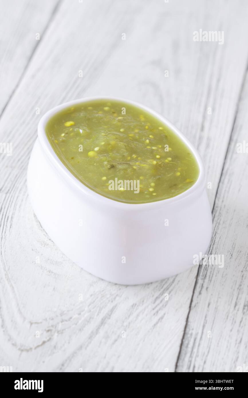 Bright green salsa verde swirled into bowl, tangy flavor with smooth texture Stock Photo