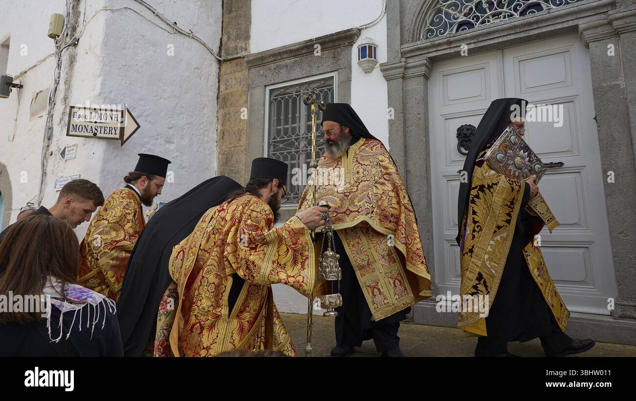 Priests in gold and black robes enter a door during a procession ...